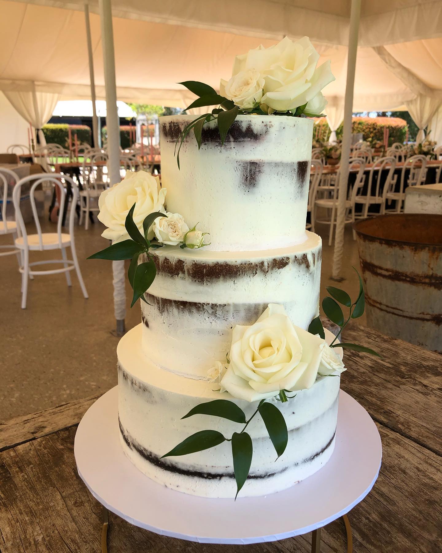 hite buttercream iced 2 tier design with white Roses and gum leaf